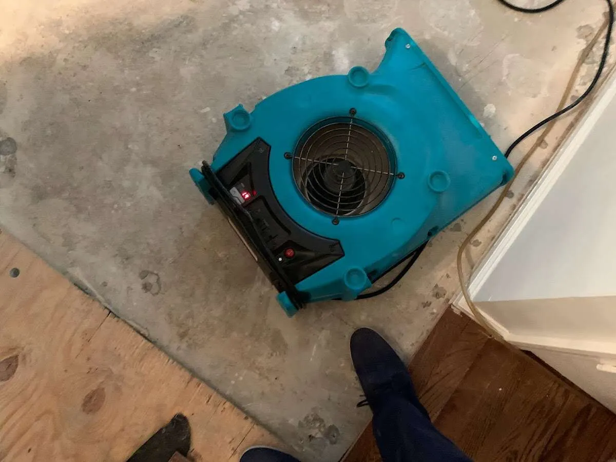 Air mover drying subfloor during Commercial Water Damage Restoration in Galveston